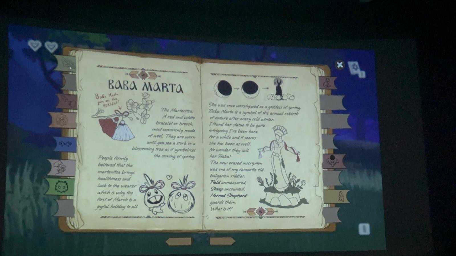The journal open on the Baba Marta page, projected on a big screen during the pitch